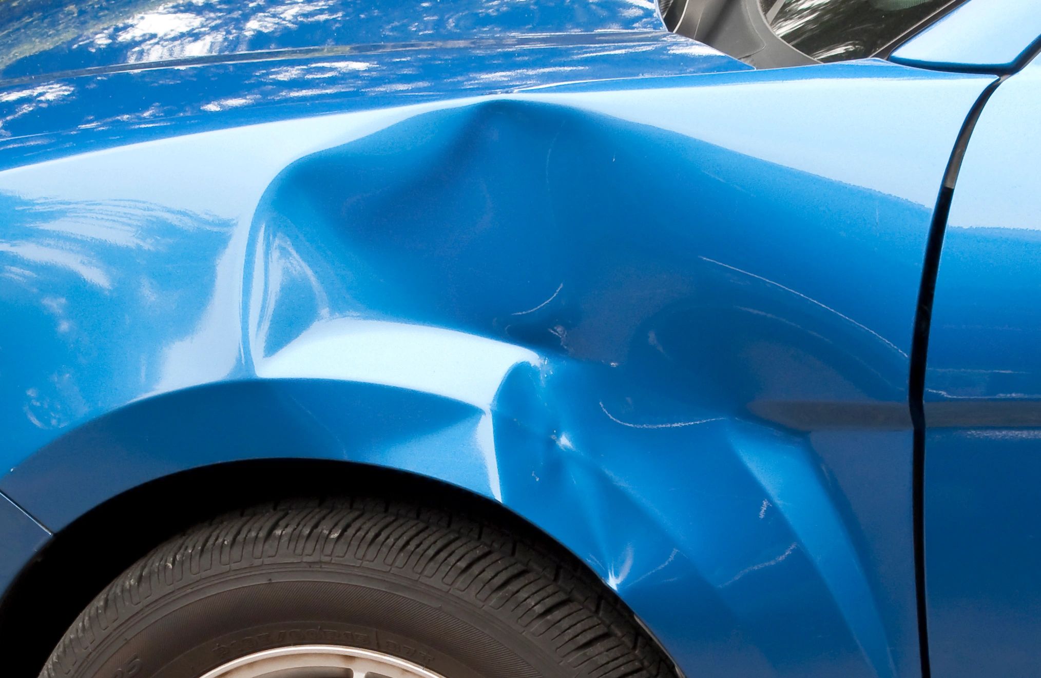 Close-up of dented front wing showing impact damage