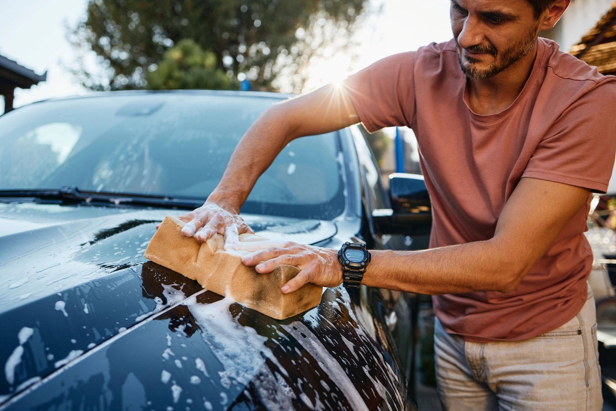 Technician working on a black car exterior